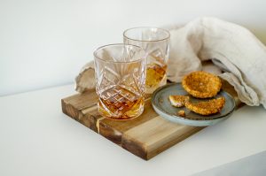 scandi lover gift guide with whisky glasses on natural wood chopping board