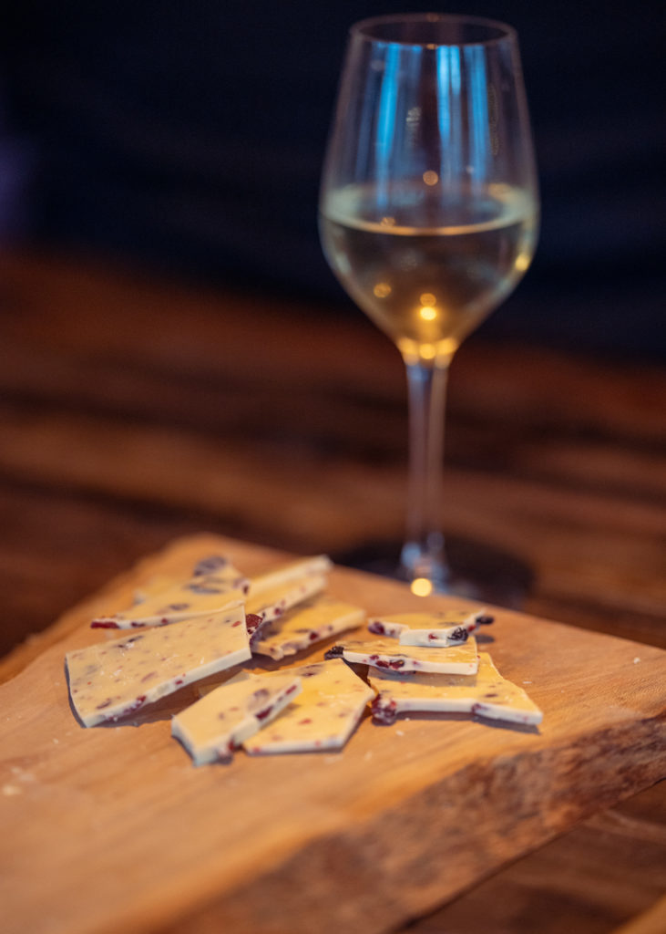 Cote du rhone white wine in a glass next to handmade chocolate by michelin starred chef, Chris Godfrey at Shoreditch Treehouse